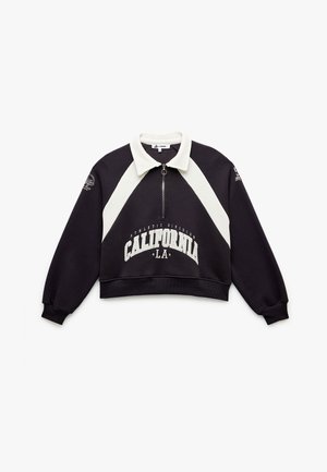 Kürzer geschnittenes Sweatshirt aus schwarzem Stoff mit einem weißen Kragen. Es verfügt über einen zentralen Reißverschluss, einen großen "California"-Druck und kontrastierende Seitenpaneele.