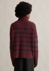 Burgunderfarbenes Sweatshirt mit schwarzen horizontalen Streifen, aus weichem Stoff, mit hohem Kragen und lockerer Passform, mit leicht verkürztem Saum.