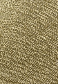 Tessuto testurizzato in oro metallico, con un motivo intrecciato di fili sottili, che crea una superficie scintillante e una finitura liscia.