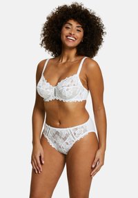 Ensemble de lingerie en dentelle blanche comprenant un soutien-gorge et une culotte, avec des motifs floraux, des bords festonnés, des bretelles réglables et un dos lisse.