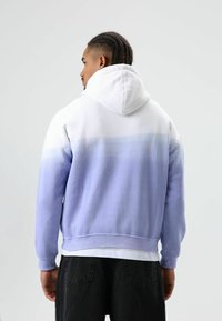 Kapuzensweatshirt mit einem Farbverlauf von Weiß zu Helllila, langen Ärmeln und einer bequemen Passform.