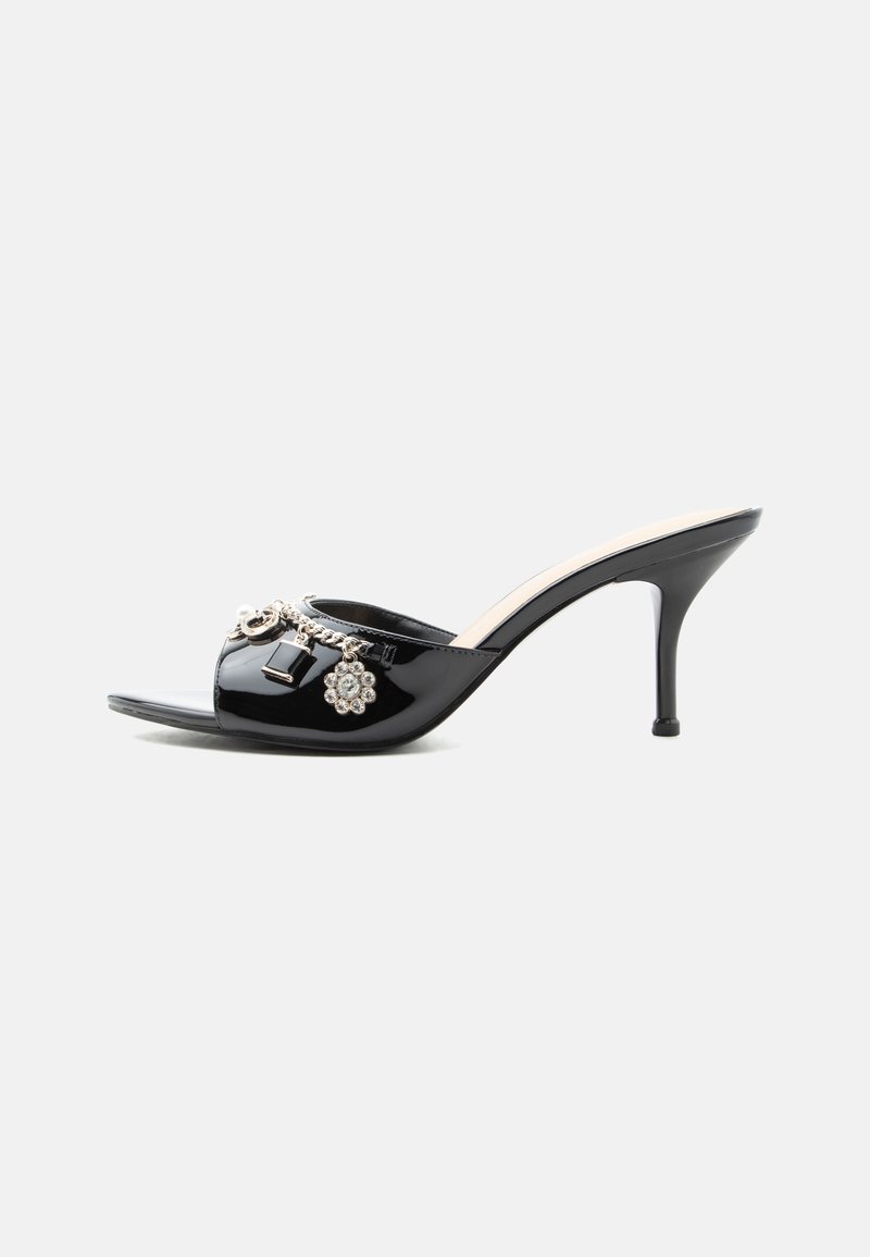 Mule à talon haut en cuir verni noir avec bout ouvert et breloques argentées décoratives comprenant une fleur et un cadenas sur la bride avant.