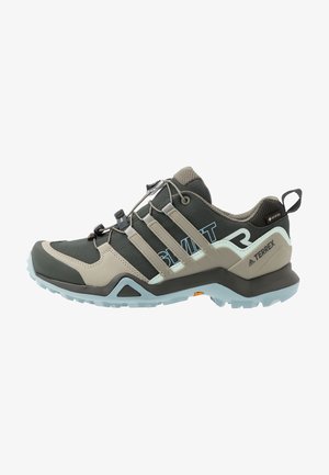Chaussure de randonnée extérieure en noir, beige et bleu clair avec tissu Gore-Tex, système de laçage rapide et semelle résistante pour utilisation sur sentiers.