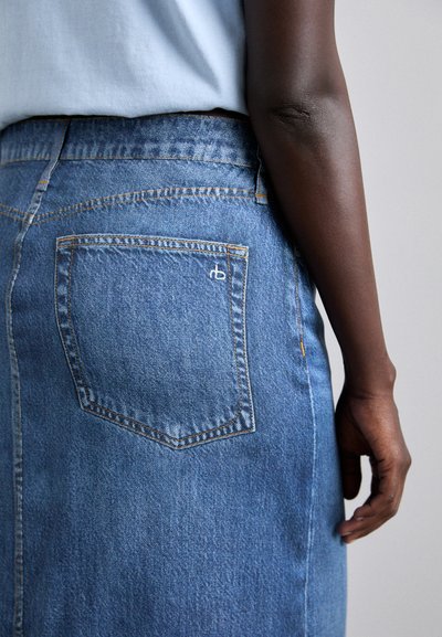 Jupe en denim avec une poche arrière, dotée de coutures contrastées. La couleur est bleu clair, avec une texture lisse et une conception taille ajustée.