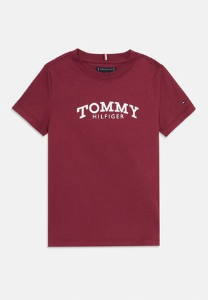 Bordeauxrotes T-Shirt mit kurzen Ärmeln und dem weißen Schriftzug "TOMMY HILFIGER" quer über der Brust sowie einer kleinen Markenflagge am linken Ärmel.