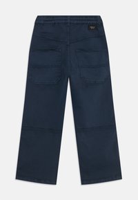 Pantaloni blu scuro con una vestibilità comoda. Presentano un elastico in vita, due ampie tasche posteriori e dettagli cuciti sul retro.