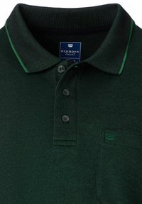 Dunkelgrünes Poloshirt aus strukturiertem Stoff, mit drei Knöpfen, kontrastierendem Kragen und einer kleinen Brusttasche links mit einem Akzentlogo.