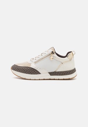Baskets blanches et beiges avec semelle marron à motifs, fermeture éclair latérale, lacets et accents dorés sur le talon et la tirette.