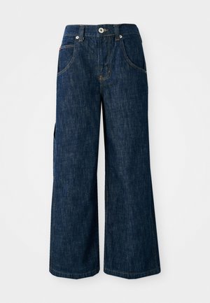 Tumedast sinine denimist laiad sääred teksad on kõrge vöökohaga, ees on taskud ja kontrastõmblused. Kangas on sileda tekstuuri ja kindla tunnetusega.