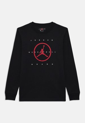 T-shirt à manches longues noir en coton avec un logo Air Jordan rouge central, accompagnée du texte "JORDAN BASKETBALL BRAND". Design classique à col rond.