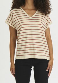 Beige stribet t-shirt med røde vandrette striber, v-hals, korte ærmer og en afslappet pasform, parret med sorte bukser.