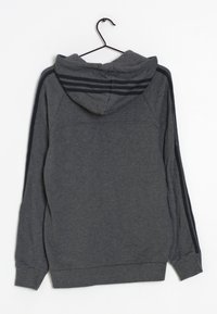 Sudadera gris con un bolsillo canguro, capucha con cordones, puños acanalados y rayas negras en cada hombro. El material parece suave y elástico.