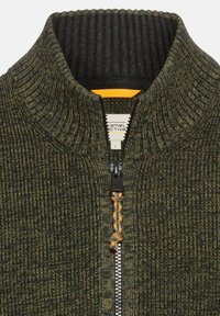 Grüne Strickjacke mit Reißverschluss und geripptem Kragen. Verfügt über einen kontrastierenden Reißverschluss mit orangen Akzenten und einer strukturierten Oberfläche. Größenetikett L sichtbar.