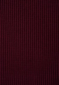 Tissu côtelé bordeaux avec une texture douce, présentant des rayures verticales également espacées qui créent une apparence structurée.