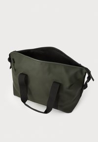 Ciemnozielona, wodoodporna torba na ramię z czarnymi tkaninowymi uchwytami, szerokim otwarciem i minimalistycznym wzornictwem. Posiada zamek błyskawiczny i wytrzymały materiał.