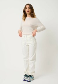 Valkoinen pitkähihainen paita, istuva, kevyt. Vain valkoiset suorat farkut, kestävä kangas, perinteinen viisi-taskumalli. Harmaat tennarit, joissa on purppurat accentit.