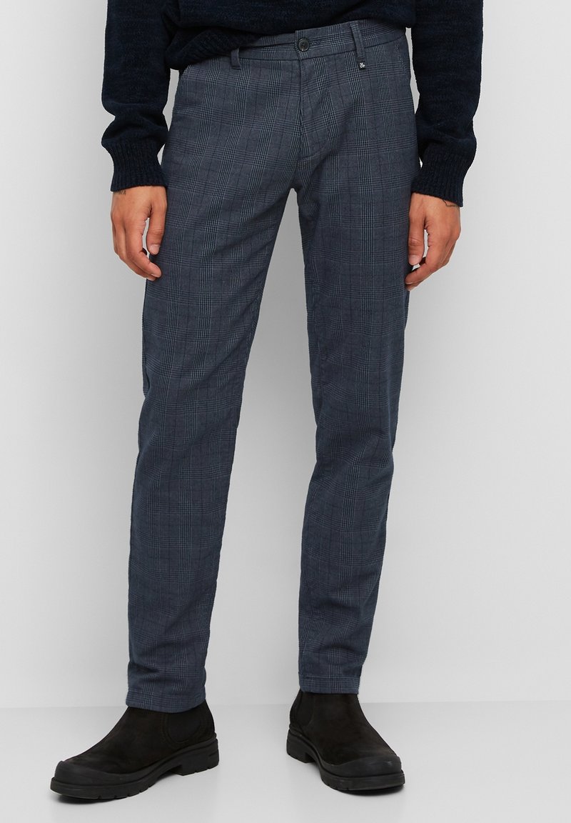 Pantaloni a quadri grigio scuro realizzati in tessuto leggero, con vestibilità slim, tasche frontali e chiusura con bottone, abbinati a stivaletti neri alla caviglia.