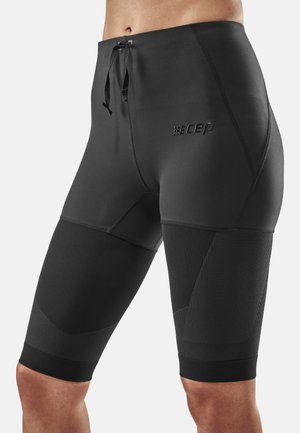 Compression shorts made of smooth black fabric, featuring a fitted design, textured accents, and an adjustable drawstring waistband.