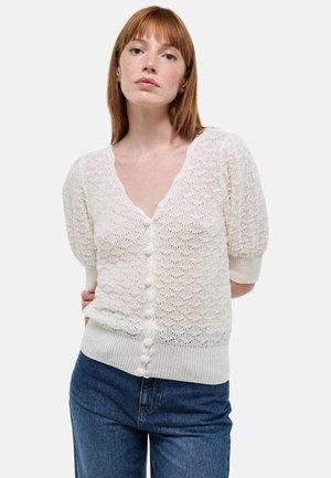 Cardigan blanc en tricot avec un col en V, des manches bouffantes courtes et des boutons décoratifs sur le devant, avec un motif texturé.
