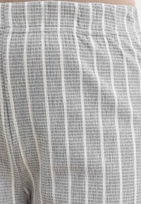 Gray and white striped fabric with a textured pattern; features a soft elastic waistband and subtle vertical lines.