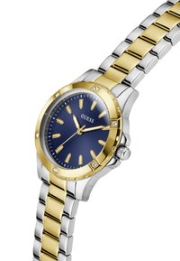 Montre en or et argent avec un cadran bleu et des marquages d'heure luminescents, dotée d'une fenêtre de date, mettant en valeur un style de bracelet élégant.