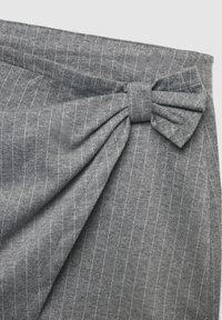 Szara tkanina z pionowymi prążkami, zdobiona szczegółem w postaci związanej kokardy. Materiał wydaje się miękki o gładkiej fakturze. Subtelny połysk.