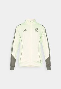 Light green athletic jacket with a high collar, zip closure, and gray accents. Features black Adidas logo and Real Madrid emblem.