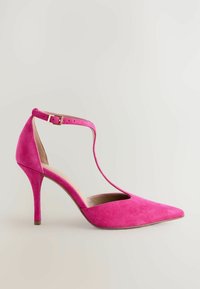 Zapato de tacón alto de ante rosa con un diseño de lado abierto, puntera afilada y tira al tobillo con hebilla de metal. Forro interior suave.
