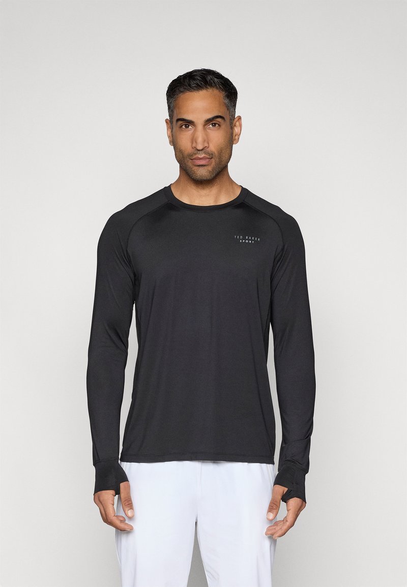 Ilga lieso juoda sportinė marškinė su apvalia apykakle, nykščio angomis ir mažas logotipas ant krūtinės. Minkšta, tampri medžiaga.