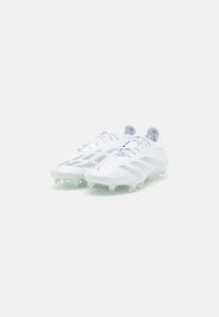 Witte voetbalschoenen met een gestructureerde bovenkant, voorzien van grijze accenten en een lichtgewicht ontwerp. Uitgerust met doorzichtige studs voor grip.