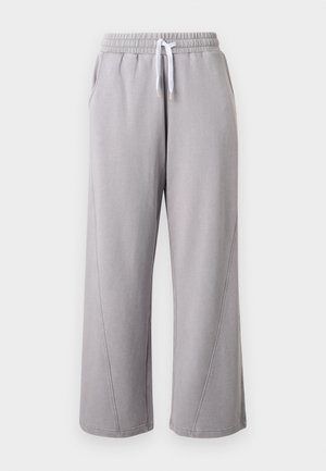 Pantaloni largi din material molton gri deschis, cu talie elastică și șnur alb, prevăzuți cu buzunare laterale și detalii cusute de-a lungul picioarelor.