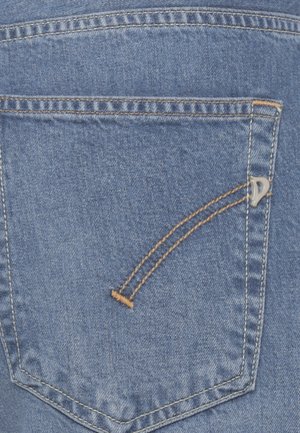 Poche arrière d'un jean en denim bleu avec une double couture orange et un petit logo métallique sur le côté droit de la poche.