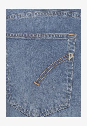 Achterzak van een blauwe spijkerbroek met oranje dubbele stiksels en een klein metalen logo aan de rechterkant van de zak.