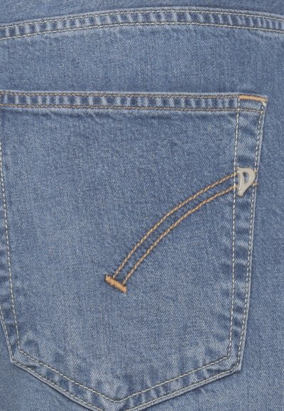 Poche arrière d'un jean en denim bleu avec une double couture orange et un petit logo métallique sur le côté droit de la poche.