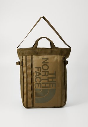 Brown roll-top backpack made of durable material; features logo print, side straps, and dual carrying handles for versatility.