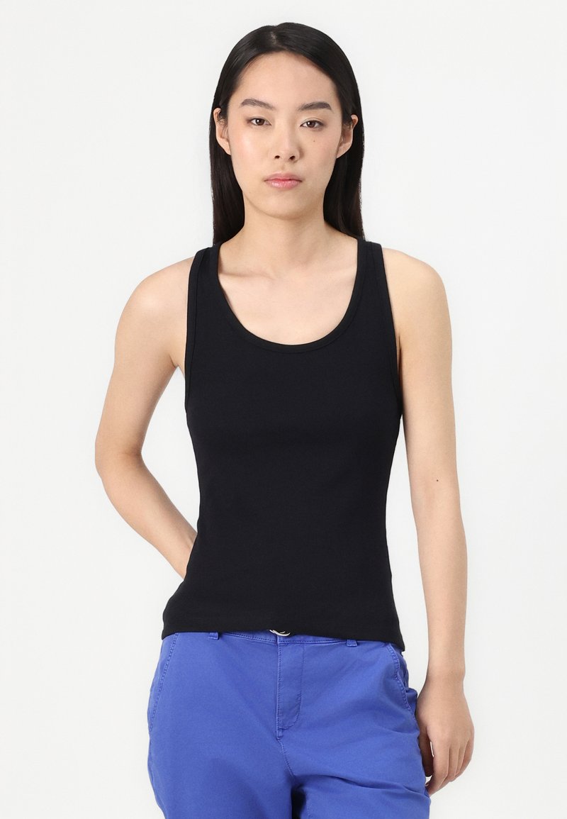 Schwarzes, ärmelloses Tanktop mit rundem Ausschnitt, aus einem glatten, dehnbaren Stoff, kombiniert mit blauen Hosen. Einfaches Design ohne Verzierungen.
