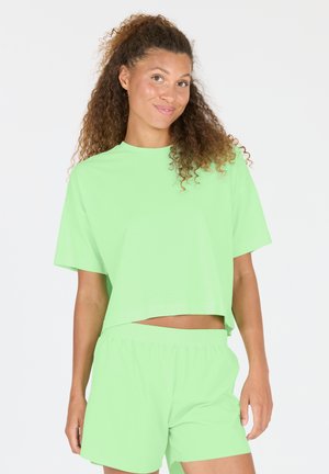 Light green cropped t-shirt with short sleeves paired with matching shorts. Smooth fabric, relaxed fit, and elastic waistband.
