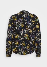 Camisa preta de manga longa com um padrão floral, apresentando flores amarelas, brancas e cor-de-rosa. Punhos abotoados e detalhe de pregas nas costas. Textura do tecido suave.