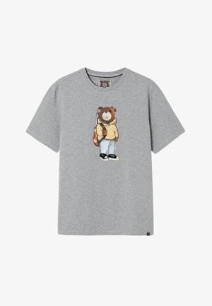 Graues Baumwoll-T-Shirt mit einem Bärenmotiv, der einen gelben Hoodie, blaue Jeans, schwarze Schuhe und einen Rucksack trägt. Kurzärmlig, mit Rundhalsausschnitt.