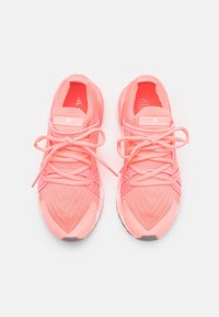 Scarpe sportive rosa con una tomaia texturizzata, punte arrotondate e lacci piatti. Presentano una suola imbottita e dettagli con logo sulla linguetta.