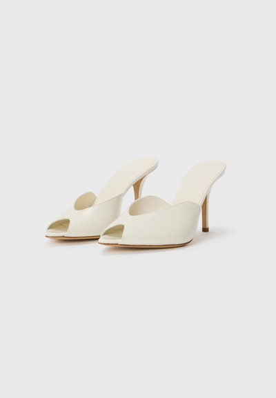 Mule-uri nude cu vârful deschis, finisaj din piele netedă, formă conturată, toc conic și design minimalist.