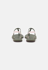 Green flip-flops with pink straps, featuring a textured footbed and rubber outsole. Simple design with a minimalist shape and lightweight material.