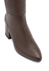Brązowy skórzany botek za kostkę z wydłużonym czubkiem i słupkowym obcasem, cechujący się minimalnym przeszyciem i gładkim wykończeniem.