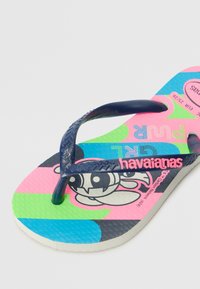 Chanclas rosas y verdes con correas azul marino, que presentan un diseño de personaje de dibujos animados en la plantilla y una suela texturizada para un mejor agarre.