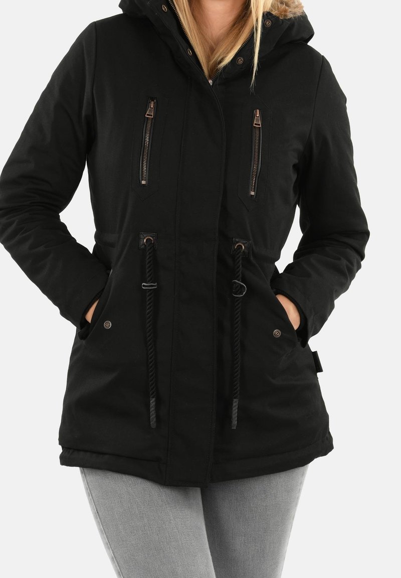 Parka noire avec capuche, dotée de poches zippées, de cordons de serrage à la taille et d'une texture lisse. Les accents incluent des accessoires en métal.