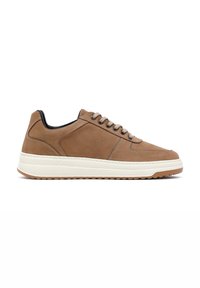 Zapatillas de ante marrón con punta redondeada, cinco ojetes, entresuela blanca, suela de goma texturizada y cuello negro en contraste.