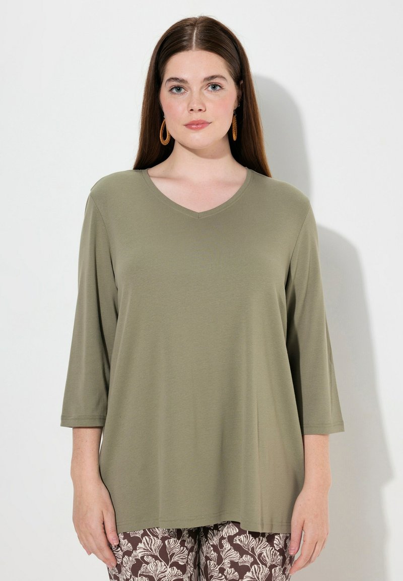 Olijfgroene V-hals shirt met driekwart mouwen, gemaakt van zachte stof, met een losse, relaxte pasvorm en een minimalistisch ontwerp.