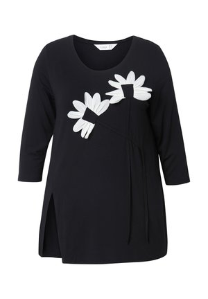 Zwart longsleeve top met ronde halslijn, voorzien van twee grote witte madelief appliqués en een split aan de zijkant. Zachte stof, casual ontwerp.