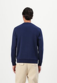 Felpa blu navy con maniche lunghe, collo a giro. Materiale in misto cotone con una texture liscia. Design minimalista.