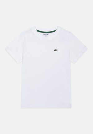 Camiseta de algodón blanca con cuello redondo y mangas cortas. Presenta un logo verde bordado en el lado izquierdo del pecho. Textura suave.
